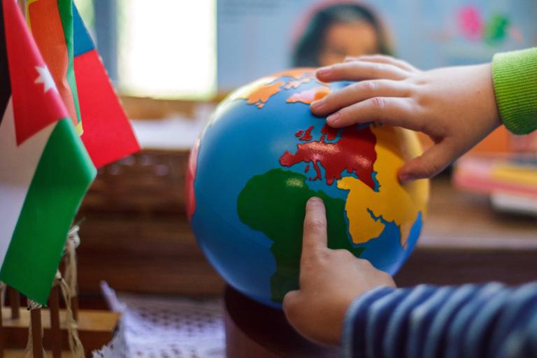 Children touching globe